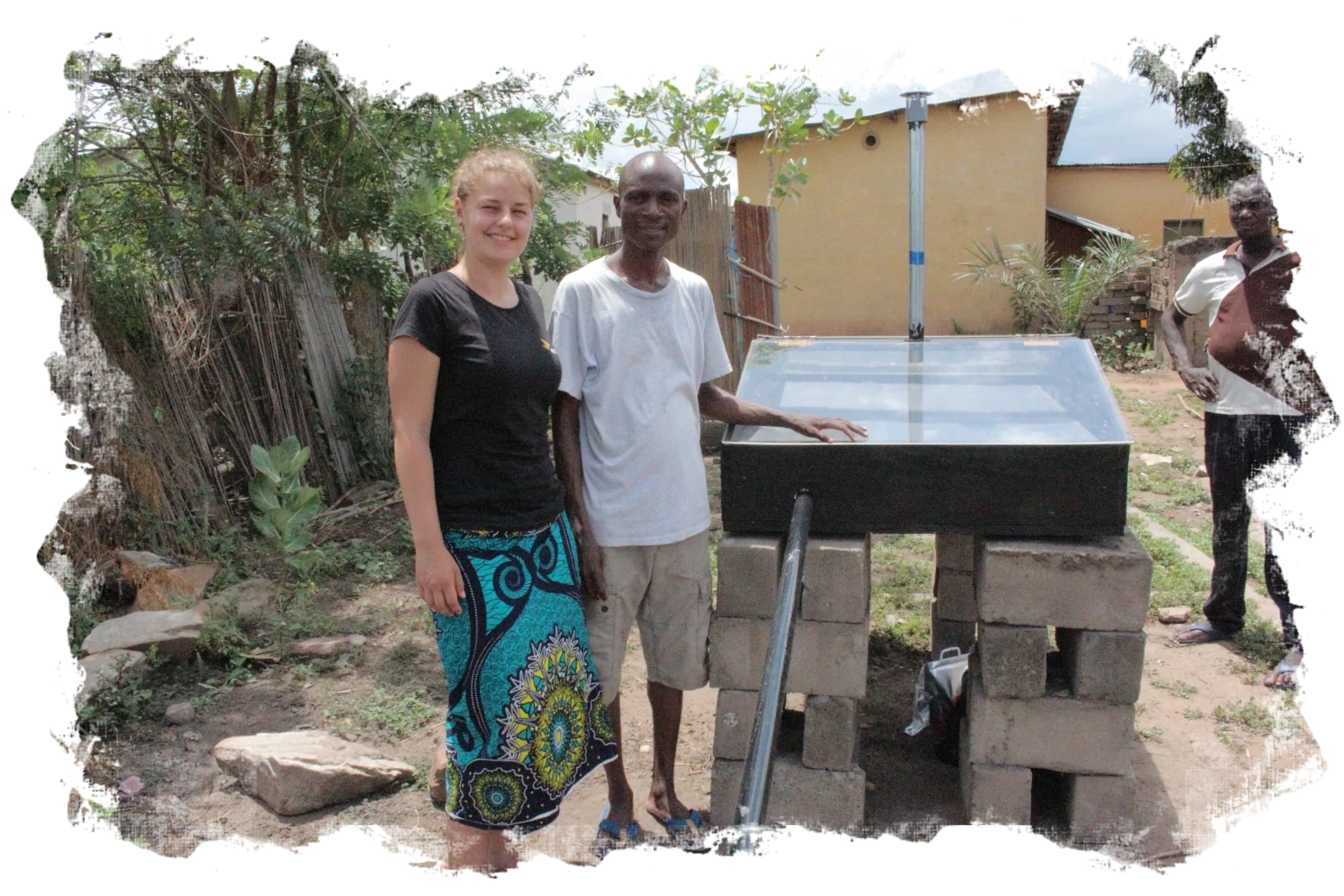 Komi Amavi und Lenia stehen vor dem ersten Solar dryer Prototypen.